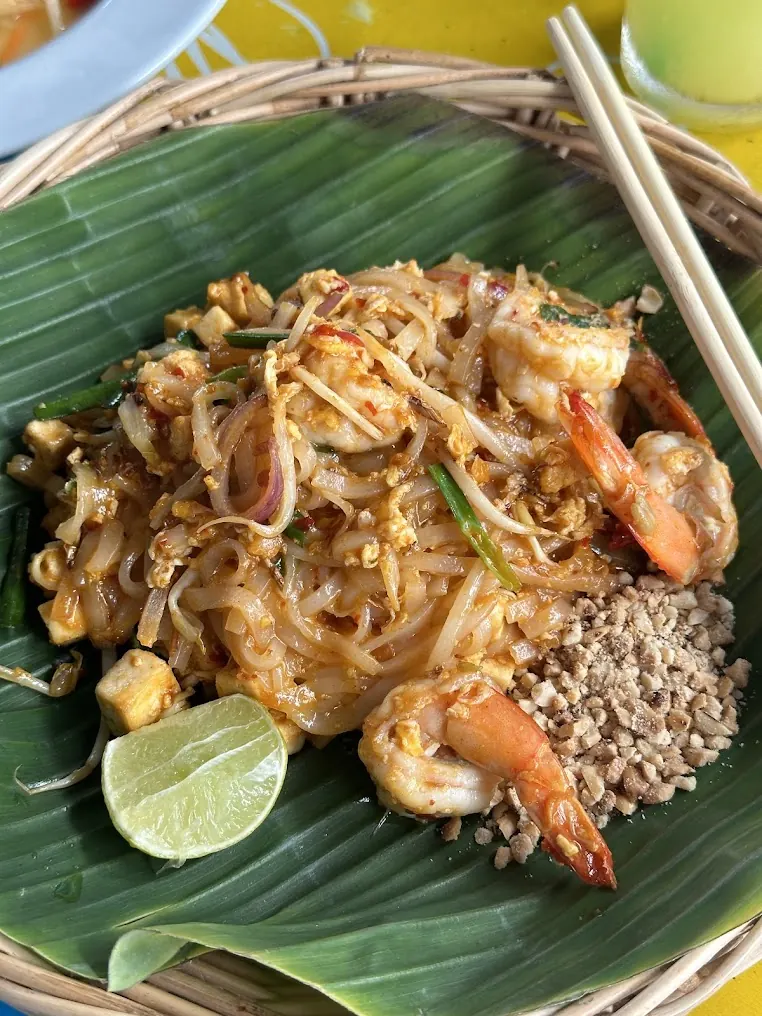 Shrimp Pad Thai with lime and crushed peanuts, served on a banana leaf at Pad Thai